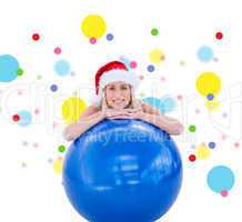 Composite image of festive fit blonde leaning on exercise ball