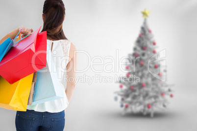 Composite image of rear view of brown hair holding shopping bags