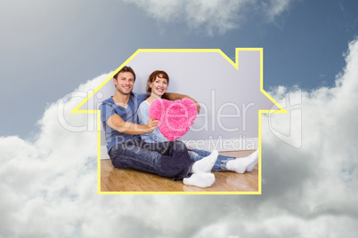 Composite image of couple holding a large heart