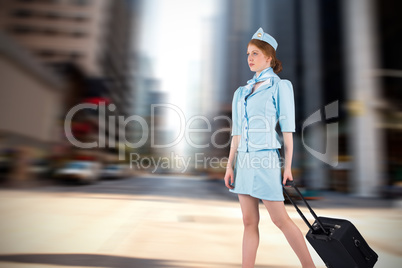 Composite image of pretty air hostess pulling suitcase