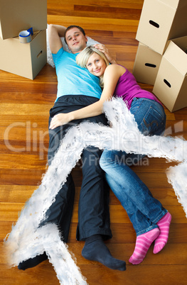 Composite image of cute couple sleeping on the floor