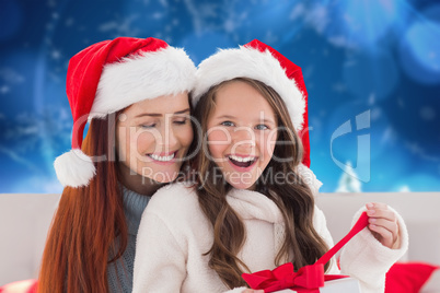 Composite image of mother and daughter opening gift