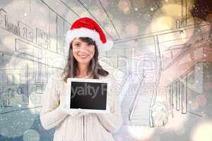 Composite image of festive brunette holding a tablet pc