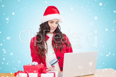 Composite image of festive brunette shopping online