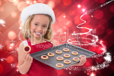 Composite image of festive little girl holding fresh cookies