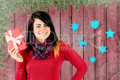 Composite image of happy brunette showing a gift