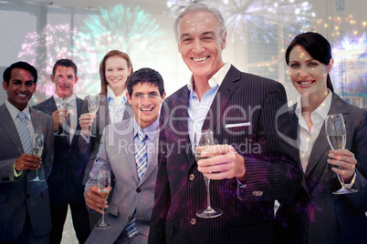 Composite image of smiling inernational business team holding gl