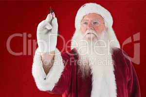 Composite image of santa writes something with a pen