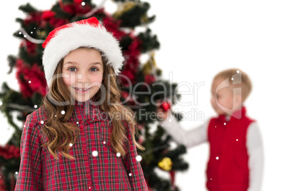 Composite image of festive little girl smiling at camera with bo