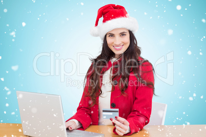 Composite image of festive brunette shopping online