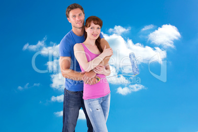 Composite image of couple hugging and holding brush