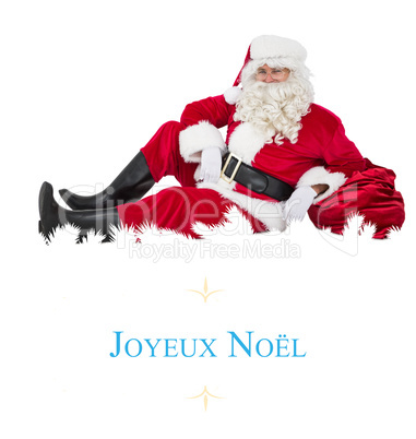 Composite image of relaxed santa sitting and leaning on his sack