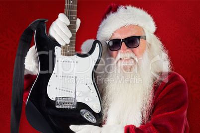 Composite image of father christmas shows a guitar