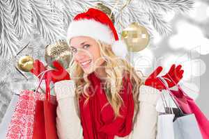 Composite image of happy festive blonde with shopping bags