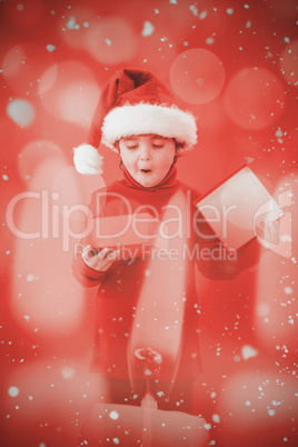 Composite image of festive little boy opening a gift