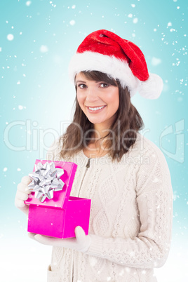 Composite image of brunette opening christmas gift while looking Composite image of brunette opening christmas gift while looking