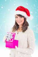 Composite image of brunette opening christmas gift while looking