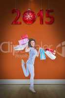 Composite image of smiling brunette jumping while holding shoppi