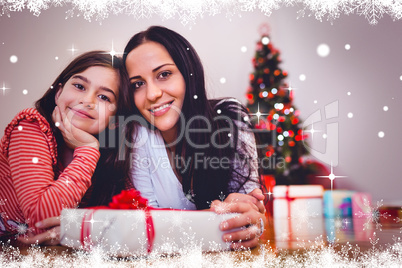 Composite image of festive mother and daughter smiling at camera