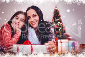 Composite image of festive mother and daughter smiling at camera