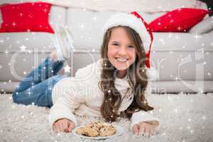 Composite image of festive little girl eating cookies