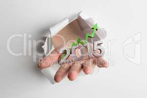 Composite image of hand bursting through paper