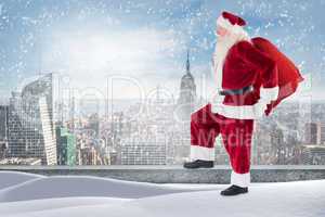Composite image of santa standing on snowy ledge