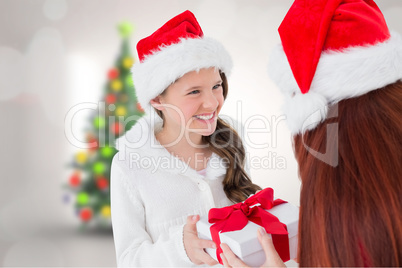 Composite image of mother and daughter with gift