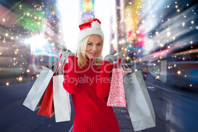 Composite image of happy festive blonde with shopping bags