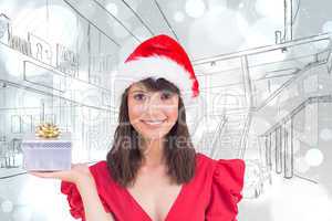 Composite image of festive brunette holding a gift