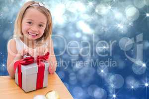 Composite image of festive little girl opening a gift
