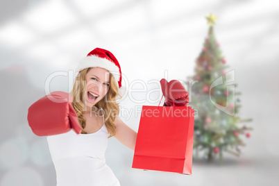 Composite image of festive blonde with boxing gloves and shoppin