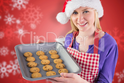 Composite image of festive blonde showing hot cookies