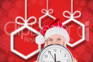 Composite image of festive blonde holding a clock