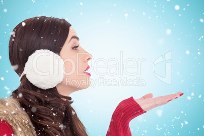 Composite image of brunette in winter clothes with hand out