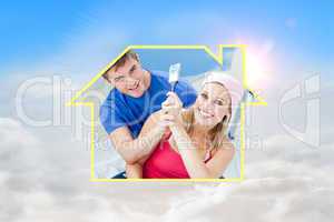 Composite image of hugging couple having fun while painting a ro