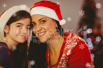 Composite image of festive mother and daughter smiling at camera