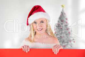 Composite image of festive cute blonde holding poster