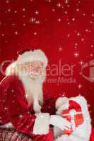 Composite image of father christmas taking red gift in his bag