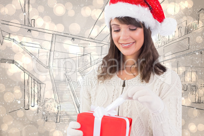 Composite image of festive brunette opening a gift