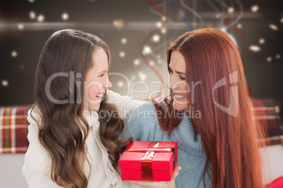 Composite image of mother and daughter with gift