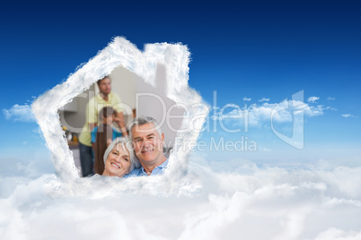 Composite image of elderly couple sitting on the couch and smili