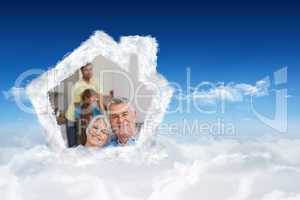Composite image of elderly couple sitting on the couch and smili