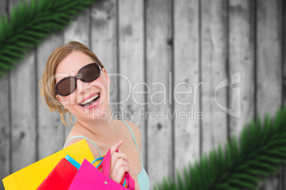 Composite image of portrait of a woman holding shopping bags wea