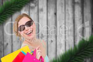 Composite image of portrait of a woman holding shopping bags wea