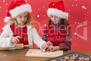 Composite image of festive little girls making christmas cookies