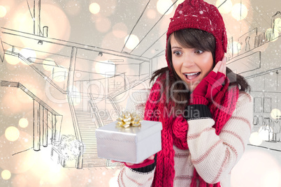 Composite image of surprised young woman holding a wrapped gift