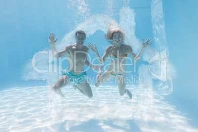Composite image of cute couple smiling at camera underwater in t
