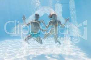 Composite image of cute couple smiling at camera underwater in t
