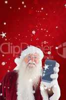 Composite image of santa claus shows a smartphone